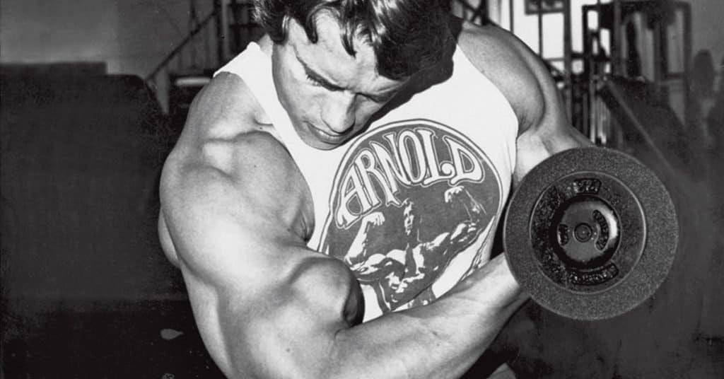 Arnold haciendo curl de bíceps, como aumentar el tamaño de tus brazos